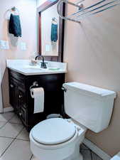 Bathroom featuring toilet, vanity, and tile patterned flooring