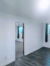 Unfurnished room with dark wood-type flooring