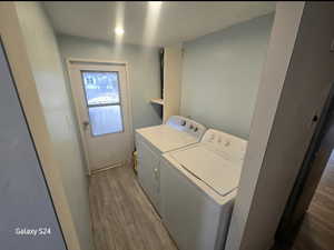 Laundry room featuring wood-type flooring and independent washer and dryer