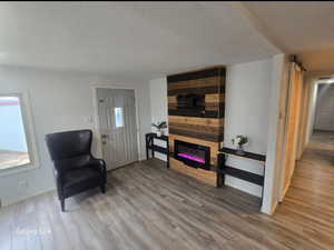 Living area featuring hardwood / wood-style flooring and a large fireplace