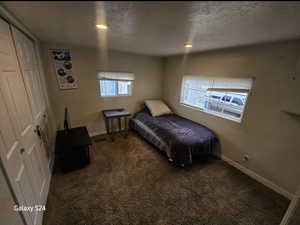 Carpeted bedroom featuring a textured ceiling