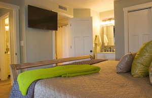 Bedroom featuring hardwood / wood-style flooring, ensuite bathroom, sink, and a textured ceiling