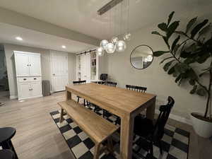 Dining space featuring a barn door and light hardwood / wood-style floors