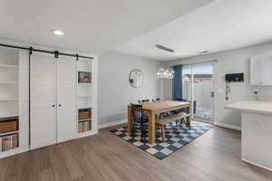 Dining area featuring a barn door, a textured ceiling, and LVP