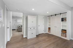 Hallway with a barn door and light wood-type flooring