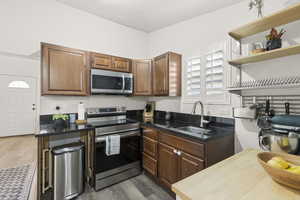 Kitchen with stainless steel appliances, dark hardwood / wood-style flooring, and sink