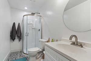 Bathroom with vanity, an enclosed shower, tile patterned floors, and toilet