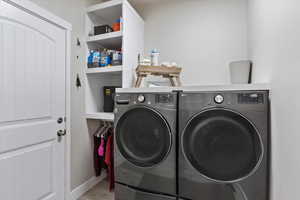 Washroom featuring light hardwood / wood-style floors and washing machine and dryer