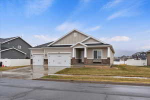 Craftsman inspired home with a garage and a front yard