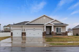 Craftsman-style house featuring a garage and a front lawn