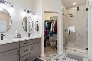 Bathroom featuring vanity and a shower with door