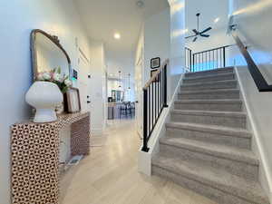 Stairs featuring wood-type flooring and ceiling fan