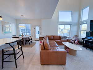 Living room with light hardwood / wood-style flooring and a high ceiling