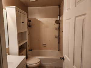 Full bathroom with tiled shower / bath, vanity, and toilet