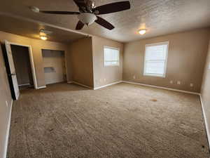 Unfurnished bedroom featuring carpet, a textured ceiling, and ceiling fan