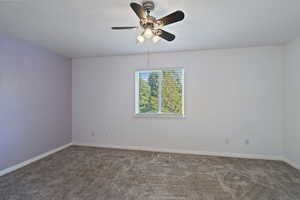 Carpeted empty room with ceiling fan