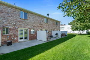 Back of property with a patio, central air condition unit, and a lawn