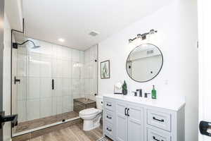 New downstairs bathroom with euro-glass enclosed shower, hardwood and large vanity.