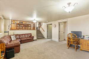 Living room featuring carpet and a textured ceiling