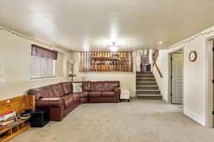 Carpeted living room featuring a textured ceiling