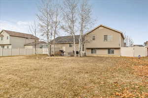 Back of house with a lawn