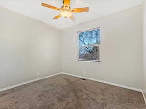 Carpeted spare room featuring ceiling fan