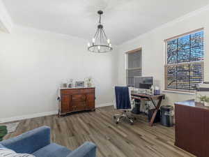 Home office with crown molding, hardwood / wood-style floors, and a notable chandelier