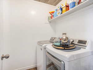 Laundry room with crown molding and washing machine and dryer