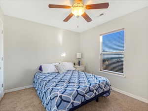 Carpeted bedroom with ceiling fan