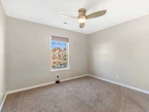 Unfurnished room featuring ceiling fan and carpet flooring