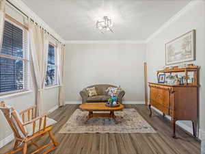 Sitting room featuring crown molding and light wood-type flooring