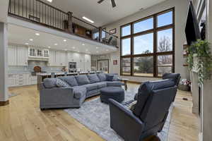 Living room featuring a wealth of natural light, light hardwood / wood-style flooring, and a towering ceiling