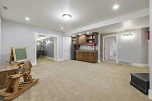 Interior space featuring black fridge, sink, and light colored carpet