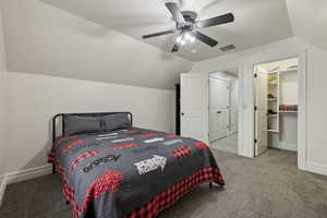 Bedroom featuring ceiling fan, carpet flooring, vaulted ceiling, and a spacious closet