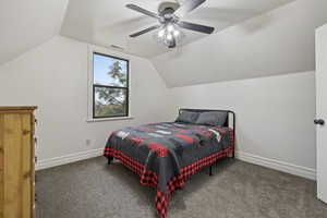 Carpeted bedroom with ceiling fan and vaulted ceiling