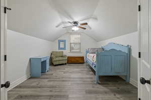 Bedroom featuring vaulted ceiling, ceiling fan, and light hardwood / wood-style flooring