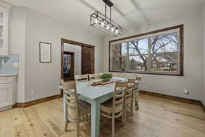 Dining space with light hardwood / wood-style flooring and a chandelier