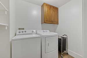 Laundry room featuring cabinets and washer and clothes dryer