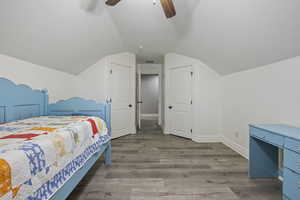 Bedroom featuring hardwood / wood-style flooring, ceiling fan, and vaulted ceiling