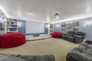 Carpeted home theater room with a wall unit AC and built in features