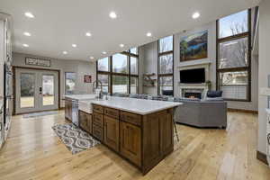 Kitchen with french doors, a kitchen bar, stainless steel appliances, a healthy amount of sunlight, and a kitchen island with sink