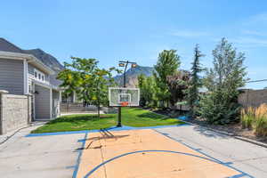 View of basketball court featuring a yard and a mountain view