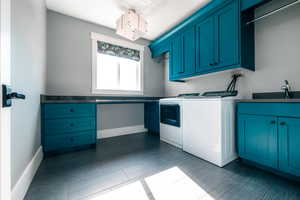 Laundry room featuring cabinets, sink, and washing machine and clothes dryer