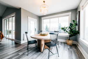 Dining space with an inviting chandelier and hardwood / wood-style flooring