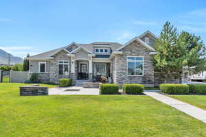 Craftsman-style home featuring a mountain view and a front lawn