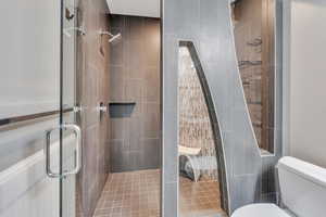 Bathroom with toilet and a shower with shower door