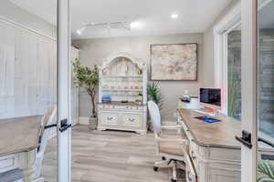 Office featuring rail lighting and light hardwood / wood-style floors