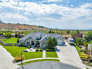 View of front of home featuring a garage, a mountain view, and a front yard