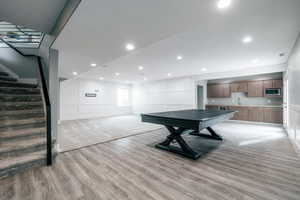 Rec room with wet bar and light hardwood / wood-style floors