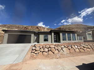 View of front of house featuring a garage, stucco siding, and driveway